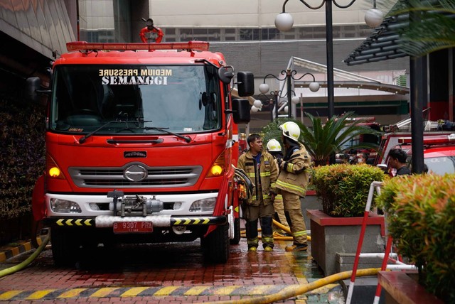 Petugas pemadam kebakaran bekerja di lokasi kebakaran di Gedung Kantor Kemekumham, Jakarta, Kamis (8/12/2022). Foto: Jamal Ramadhan/kumparan