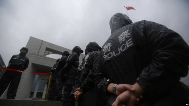 Petugas polisi berjaga di Pengadilan Menengah Rakyat Kota Hefei di mana persidangan pembunuhan Gu Kailai, istri politisi China terguling Bo Xilai, berlangsung di Hefei, Provinsi Anhui, China, 9 Agustus 2012. Foto: AP Photo