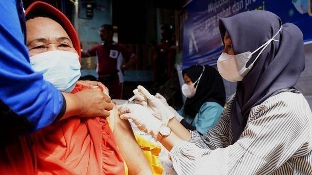Seorang wanita saat melakukan vaksinasi di Palembang. Foto: Ari Priyanto/Urban Id)