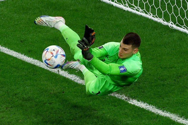 Penjaga gawang Timnas Kroasia Dominik Livakovic menepis tendangan penalti pemain Timnas Brasil pada pertandingan perempat final Piala Dunia 2022 Qatar di Education City Stadium, Doha, Qatar. Foto: Lee Smith/REUTERS