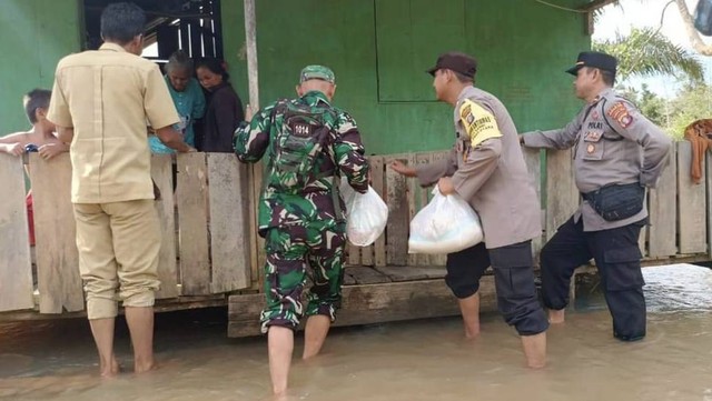 TNI-Polri bersama aparatur desa menyalurkan bantuan untuk korban banjir di Desa Dau, Kecamatan Arut Utara beberapa hari lalu. Foto: IST/InfoPBUN