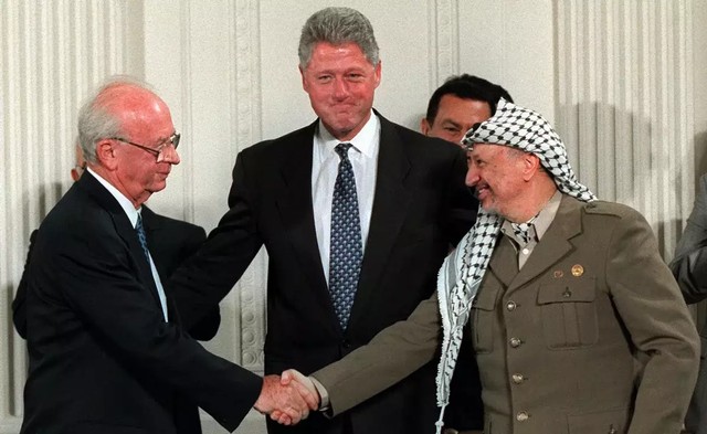 Yitzhak Rabin (kiri) saat menyetujui kesepakatan sementara dengan pemimpin PLO, Yasser Arafat, pada tahun 1995. Sumber: npr.org