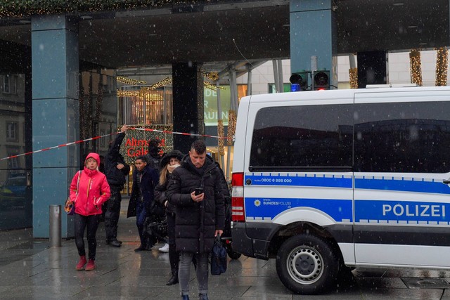 Orang-orang berjalan saat petugas polisi mengamankan area pasar Natal di Dresden, Jerman, Sabtu (10/12/2022). Foto: Matthias Rietschel/REUTERS
