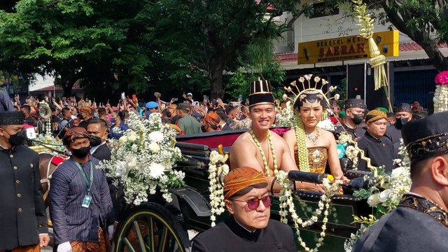 Kirab budaya, Kaesang dan Jokowi bagikan suvenir dompet. Foto: Dok. Istimewa