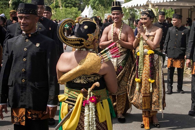 Pengantin yang juga putra bungsu Presiden Joko Widodo Kaesang Pangarep (ketiga kanan) dengan Erina Gudono (kedua kanan) berjalan masuk Pura Mangkunegaran untuk mengikuti ritual Tasyakuran pernikahan di Solo, Jawa Tengah, Minggu (11/12/2022). Foto: Mohammad Ayudha/Antara Foto