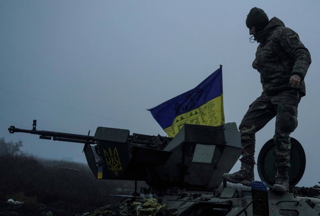 Sejumlah tentara Ukraina beristirahat di sebuah jalan di wilayah Kherson, Ukraina, Jumat (9/12/2022). Foto: Anna Voitenko/Reuters