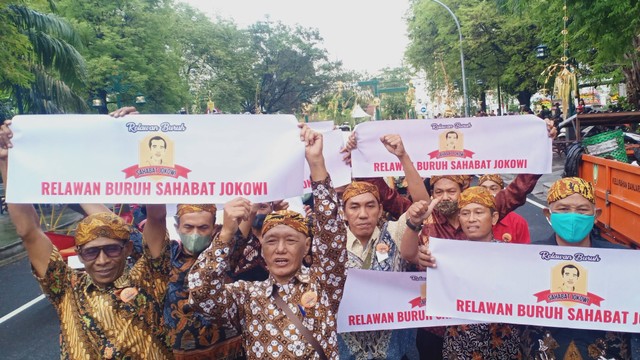 Buruh dari Sukoharjo yang tergabung dalam Relawan Buruh Sahabat Jokowi melakukan aksi dengan berjalan di sepanjang Jalan Diponegoro, Solo, Minggu (11/12/2022). FOTO: Agung Santoso