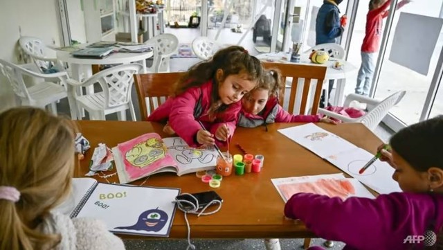 Anak-anak pengungsi menggambar di kamp liburan Laut Hitam Bulgaria, yang pemiliknya orang Rusia telah menampung keluarga Ukraina. Foto: Nikolay Doychinov/AFP