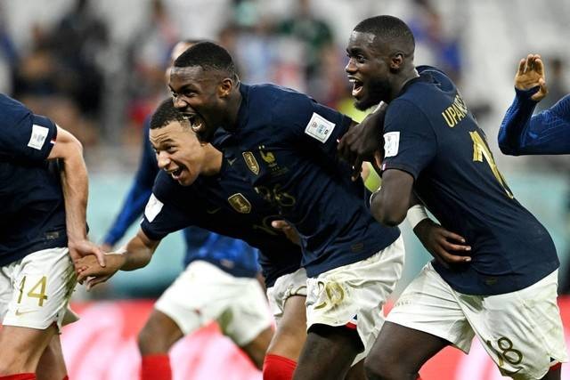 Pemain Prancis Kylian Mbappe, Marcus Thuram dan Dayot Upamecano merayakan kemenangannya dan lolos ke perempat final Piala Dunia 2022, di Stadion Al Thumama, Doha, Qatar, Minggu (12/4/2022). Foto: Dylan Martinez/REUTERS