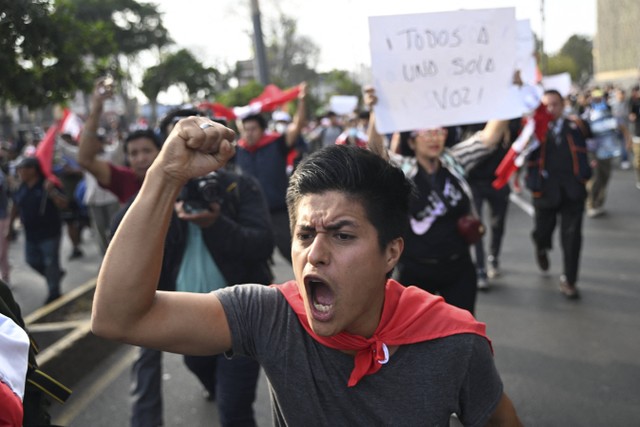 Pendukung mantan Presiden Pedro Castillo meneriakkan slogan selama protes di dekat Kongres di Lima, Peru, Senin (12/12/2022). Foto: Ernesto Benavides/AFP