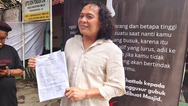 Kuasa hukum orang tua siswa SDN Pondok Cina 1, Deolipa Yumara menunjukan bukti surat laporan di Polda Metro Jaya, Jakarta, Rabu (14/12/2022). Foto: Dok. Istimewa