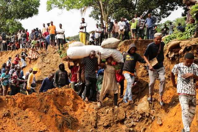 Warga melewati jalan yang rusak parah menyusul hujan lebat yang menyebabkan banjir dan tanah longsor, di pinggiran Kinshasa, Republik Demokratik Kongo. Foto: Justin Makangara/REUTERS