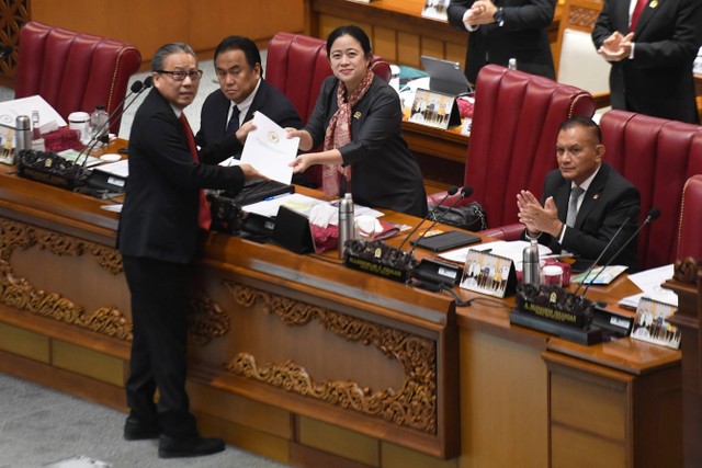 Ketua DPR Puan Maharani (kedua kanan) menerima berkas hasil rapat dan pandangan mini fraksi dari Ketua Panja pembahasan Rancangan Undang-Undang (RUU) tentang Pengembangan dan Penguatan Sektor Keuangan (PPSK) Dolfie OFP (kiri) saat rapat paripurna. Foto: Hafidz Mubarak A/Antara Foto