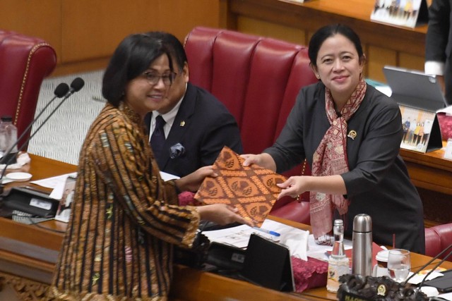 Menteri Keuangan Sri Mulyani Indrawati (kiri) menyerahkan berkas pendapat akhir presiden terkait pembahasan Rancangan Undang-Undang (RUU) tentang Pengembangan dan Penguatan Sektor Keuangan (PPSK) kepada Ketua DPR Puan Maharani saat rapat paripurna. Foto: Hafidz Mubarak A/Antara Foto