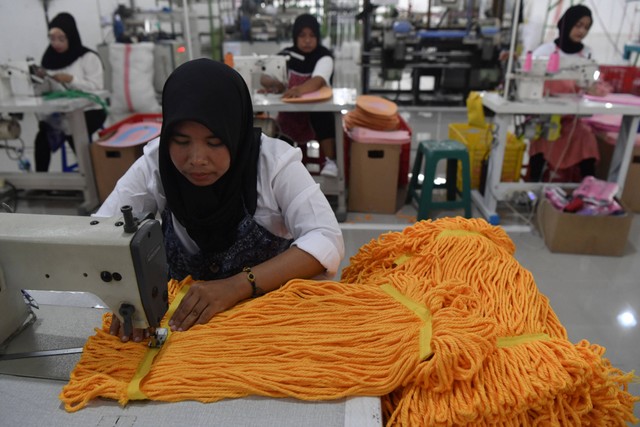 Sejumlah pekerja menyelesaikan kain pel di pabrik baru PT Klinko Karya Imaji Tbk, Gresik, Jawa Timur, Kamis (15/12/2022). Foto: Zabur Karuru/Antara Foto