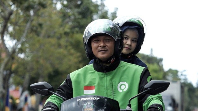 Hassanudin, driver GoRide bersama dengan penumpang.  Foto: Gojek