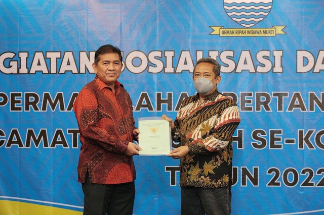 Wali Kota Bandung, Yana Mulyana saat menerima sertifikat tanah milik Pemkot Bandung dari Kepala Kantor Pertanahan Kota Bandung, Nugraha di Hotel Jayakarta, Kamis 15 Desember 2022.
