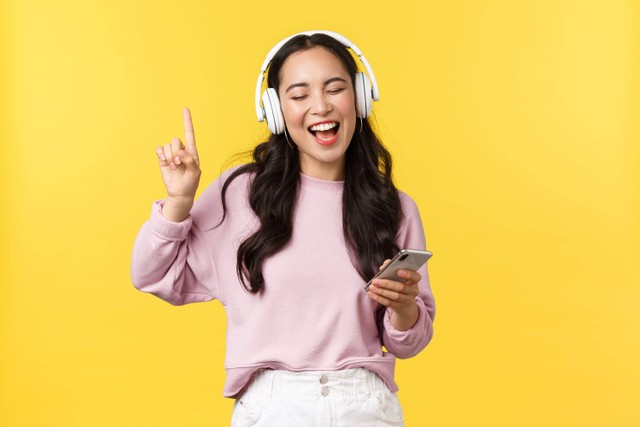 <a href="https://www.freepik.com/free-photo/people-emotions-lifestyle-leisure-beauty-concept-carefree-happy-asian-woman-listening-music-wireless-headphones-holding-mobile-phone-singing-along-favorite-song-yellow-background_17064301.htm#query=musik&position=6&from_view=search&track=sph">Image by benzoix</a> on Freepik
