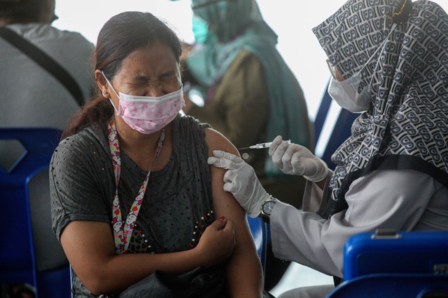 Petugas kesehatan menyuntikkan vaksin COVID-19 dosis ketiga atau booster I kepada warga di salah satu pusat perbelanjaan di Batam, Kepulauan Riau, Jumat (16/12/2022). Foto: Teguh Prihatna/ANTARA FOTO