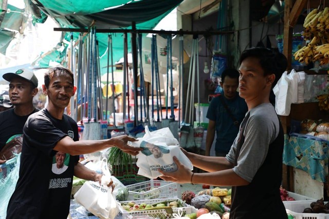 Kolaborasi Warteg (Kowarteg) Indonesia memberikan paket makanan, centong nasi, beserta kaus ke pedagang di Pasar Bambu Kuning, Tanjung Priok, Jakarta Utara. Foto: Dok. Istimewa