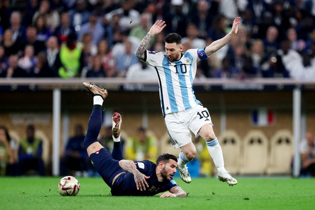 Pemain Argentina Lionel Messi beraksi dengan pemain Prancis Theo Hernandez pada final Piala Dunia 2022, di Stadion Lusail, Lusail, Qatar, Minggu (18/12/2022). Foto: Lee Smith/REUTERS
