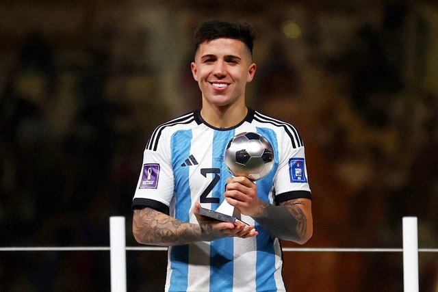 Pemain Argentina Enzo Fernandez berpose dengan piala penghargaan Pemain Muda Terbaik di Stadion Lusail, Lusail, Qatar, Minggu (18/12/2022). Foto: Carl Recine/REUTERS