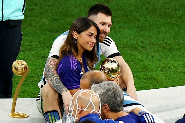 Pemain Argentina Lionel Messi merayakan kemenangan Piala Dunia 2022 dengan istrinya, Antonela Roccuzzo, di Stadion Lusail, Lusail, Qatar, Minggu (18/12/2022). Foto: Molly Darlington/REUTERS