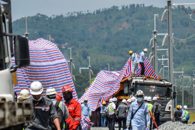 Pekerja menutupi bangkai kereta teknis yang mengalami kecelakaan menggunakan kain di Campaka Mekar, Kabupaten Bandung Barat, Jawa Barat, Senin (19/12/2022).  Foto: Raisan Al Farisi/ANTARA FOTO