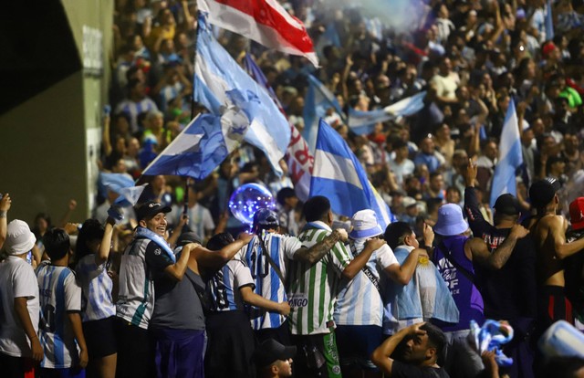 Fans berkumpul menjelang kedatangan bus tim Argentina, di luar Markas Besar Asosiasi Sepak Bola Argentina, di Buenos Aires, Argentina, Selasa (20/12/2022). Foto: Matias Baglietto/REUTERS