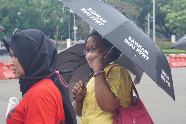 Sejumlah peserta yang tergabung dalam Ibu-ibu PRT (Pekerja Rumah Tangga) menggelar aksi di Taman Aspirasi Monumen Nasional, Jakarta pada Rabu (21/12/2022). Foto: Iqbal Firdaus/kumparan