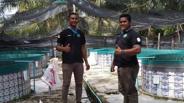 Misnadi (kiri) dan rekannya melakukan budidaya lele. Foto: dok. Misnadi