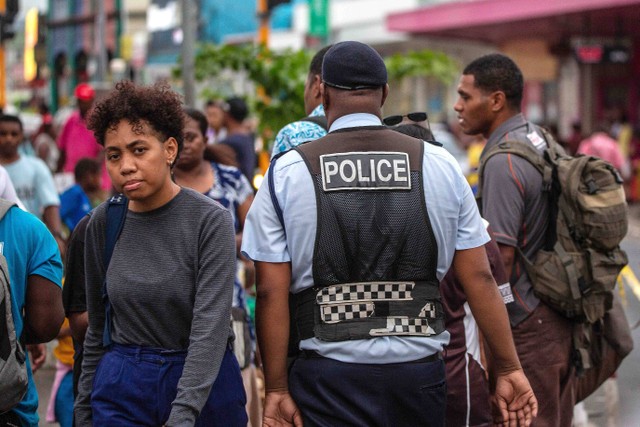 Seorang polisi berpatroli di sebuah jalan setelah pemilu di ibu kota Fiji, Suva, pada Kamis (22/12/2022). Foto: Leon Lord/AFP