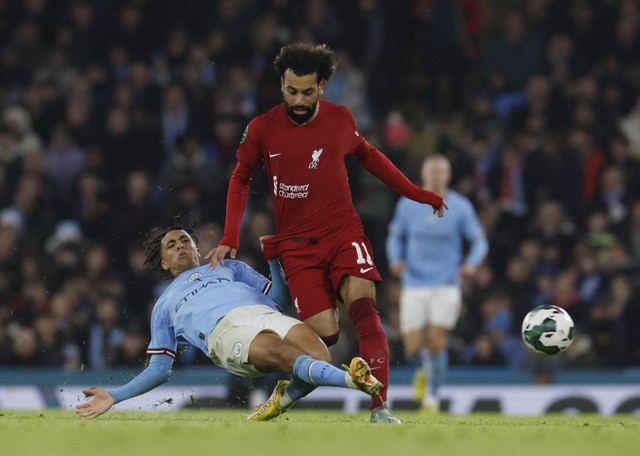 Pemain Liverpool Mohamed Salah duel dengan Rico Lewis dari Manchester City di Stadion Etihad, Manchester, Inggris. Foto: Jason Cairnduff/Reuters