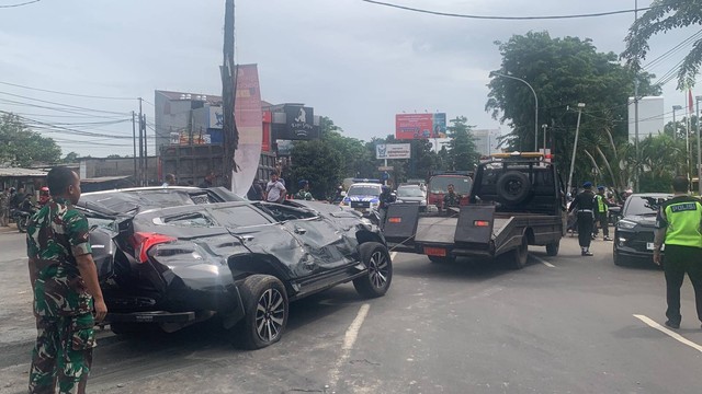 Petugas menderek mobil Pajero Sport yang tertimpa truk pasir di Jalan Alternatif Cibubur. Foto: Rinjani Meisa/kumparan