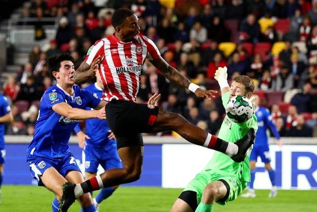 Pemain Brentford Ivan Toney berebut bola dengan pemain Gillingham Elkan Baggott pada pertandingan babak ketiga Piala Carabao di Brentford Community Stadium, London, Inggris. Foto: David Klein/REUTERS