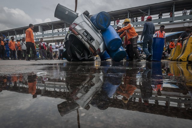 Petugas mengevakuasi mobil yang jatuh ke laut di Dermaga II Pelabuhan Merak, Kota Cilegon, Banten, Sabtu (24/12/2022). Foto: Muhammad Bagus Khoirunas/Antara Foto