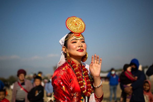 Seorang perempuan dari komunitas Kirat mengenakan pakaian adat saat menari di festival Sakela, Kathmandu, Nepal.