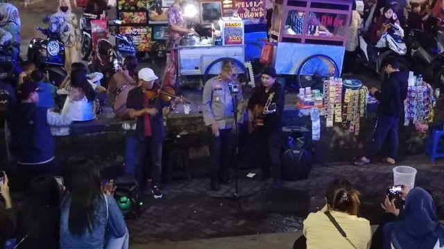 Kapolsek Tambora bernyanyi bersama dengan pengamen jalanan di depan Mall Seasons City, Jakarta Barat. Foto: Dok. Istimewa