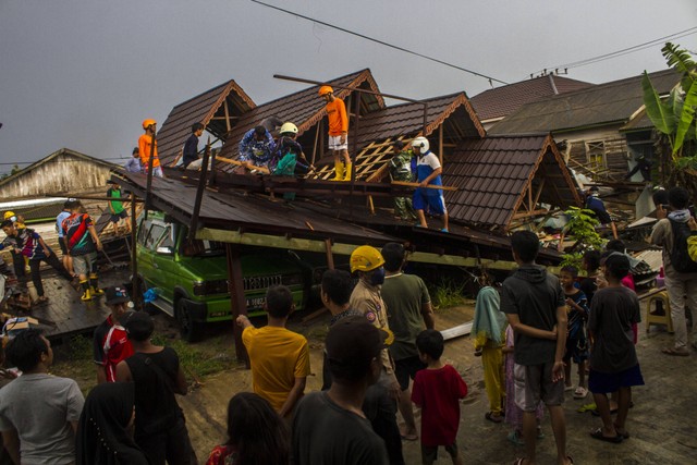 Warga bersama relawan bergotong royong menyingkirkan puing-puing rumah yang roboh di kawasan Sungai Andai, Banjarmasin, Kalimantan Selatan, Minggu (25/12/2022). Foto: Bayu Pratama S/ANTARA FOTO