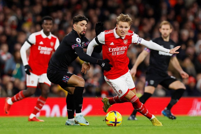 Pemain Arsenal Martin Odegaar berusaha melewati pemain West Ham United Lucas Paqueta pada pertandingan lanjutan Liga Inggris di Emirates Stadium, London, Inggris. Foto: Andrew Couldridge/REUTERS