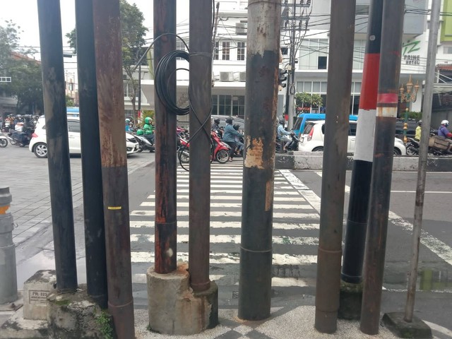 Keberadaan tiang listrik dan provider yang menutup akses zebra cross di Jalan Jenderal Basuki Rachmat, Kota Malang. Foto/M Sholeh