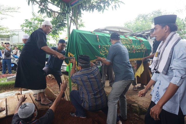Sejumlah keluarga dan kerabat menghadiri pemakaman Abdul Hamid alias Pak Ogah di TPU Jatisari 1 di kawasan Bekasi, Jawa Barat pada Kamis (29/12). Foto: Iqbal Firdaus/kumparan