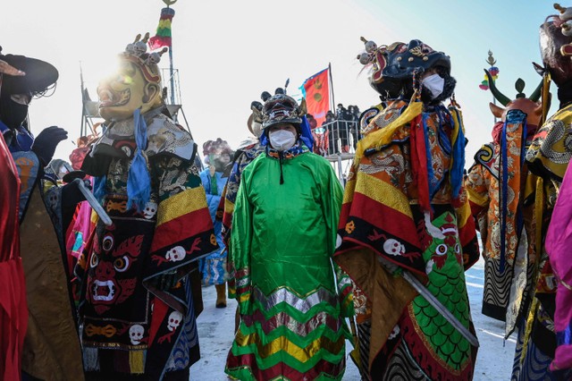 Masyarakat adat ambil bagian dalam upacara pembukaan Festival Perikanan Musim Dingin Danau Chagan tahunan di Songyuan, di provinsi Jilin, Tiongkok timur laut pada Rabu (28/12/2022). Foto: Giok Gao/AFP