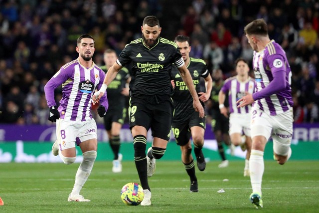 Pemain Real Madrid Karim Benzema beraksi bersama pemain Real Valladolid Monchu di Estadio Jose Zorrilla, Valladolid, Spanyol, Jumat (30/12/2022). Foto: Violeta Santos Moura/REUTERS