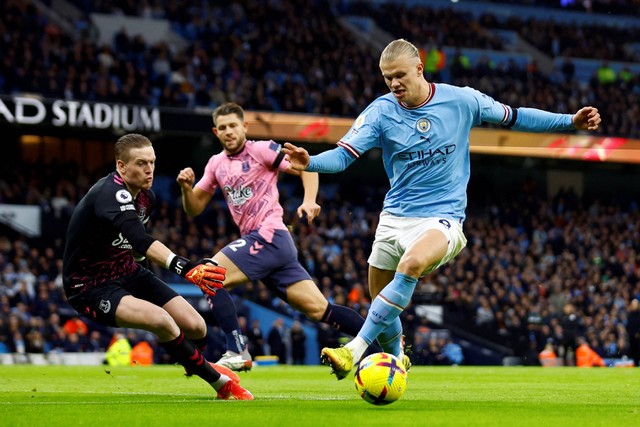 Pemain Manchester City Erling Braut Haaland beraksi dengan pemain Everton Jordan Pickford di Stadion Etihad, Manchester, Inggris, Sabtu (31/12/2022). Foto: Andrew Boyers/REUTERS