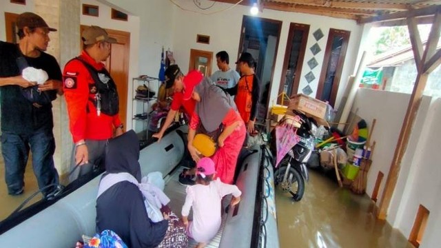 Petugas Badan Penaggulangan Bencana Daerah Kota Pekalongan sedang melakukan proses evakuasi warga terdampak banjir di Pekalongan, Minggu (1/1/2023). Foto: ANTARA/HO-Humas Kota Pekalongan