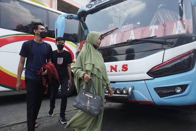 Penumpang mengambil barang setelah turun dari Bus di Terminal Kampung Rambutan pada Minggu (1/1/2023). Foto: Iqbal Firdaus/kumparan