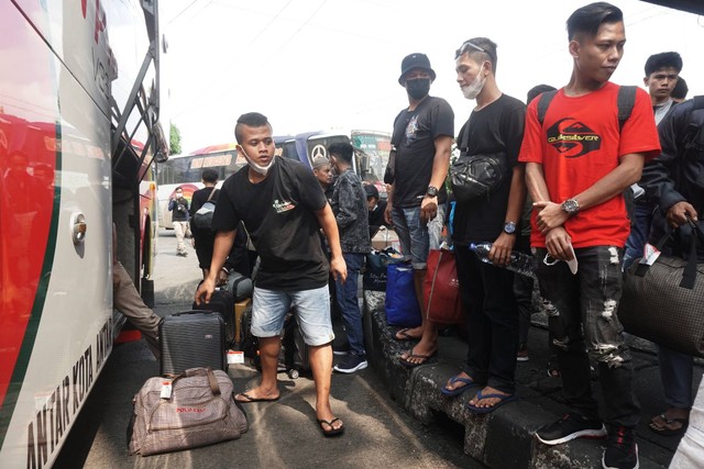 Penumpang mengambil barang setelah turun dari Bus di Terminal Kampung Rambutan pada Minggu (1/1/2023). Foto: Iqbal Firdaus/kumparan