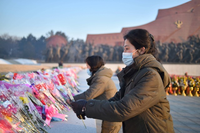 Warga Korea Utara meletakkan bunga untuk memberi penghormatan saat mengunjungi patung Presiden Kim Il Sung dan Ketua Kim Jong Il di Bukit Mansu di Pyongyang Minggu (1/1/2023). Foto: Kim Won Jin / AFP