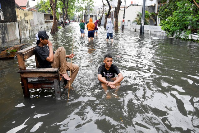 Warga bermain air saat terjadinya banjir di kawasan Dukuh Barat, Lagoa, Jakarta Utara, Minggu (1/1/2023). Foto: M Risyal Hidayat/Antara Foto 